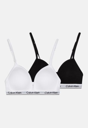 Dos sujetadores triangulares en blanco y negro, hechos de algodón suave, con tirantes finos y una banda elástica con la marca que lleva el texto "Calvin Klein".