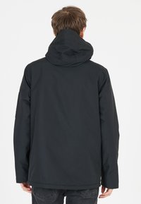 Sort vandtæt jakke med hætte, der har en glat tekstur, lange ærmer og en let buet kant. Ingen synlige logoer eller udsmykninger.