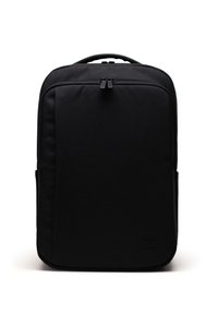 Mochila negra con una textura de tela suave, forma rectangular, doble cremallera y un discreto parche de la marca en la parte frontal.