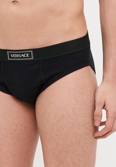 Fekete pamut alsónadrág texturált derékszíjjal, amelyen Versace logó folt található, testhezálló kialakítással és vízszintes varrási részletekkel.