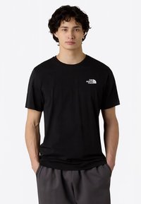 T-shirt nera a maniche corte realizzata in tessuto liscio, con un piccolo logo bianco sul petto a sinistra, vestibilità comoda e collo rotondo.