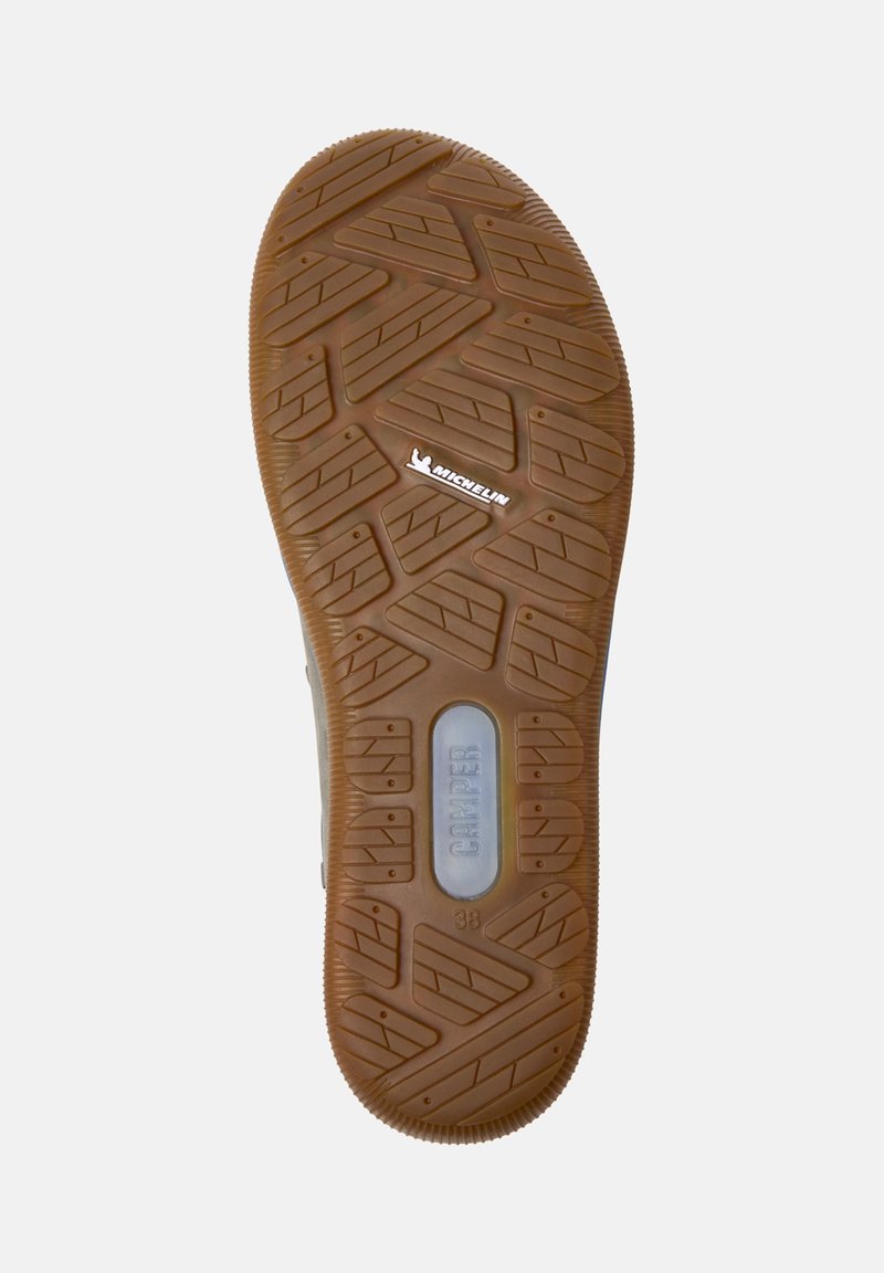 Zool van een schoen met een getextureerd rubberpatroon, gemarkeerd met "Michelin" en "Camper," en aangevend maat 38.
