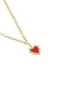 Collar de cadena de oro que presenta un colgante en forma de corazón rojo con un diseño texturizado de rayos de sol, rodeado de pequeños acentos decorativos.