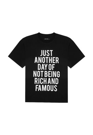 Schwarzes Baumwoll-T-Shirt mit kurzen Ärmeln, das in fettem Weiß den Text "NUR EIN WEITERER TAG, AN DEM MAN NICHT REICH UND BERÜHMT IST" trägt.
