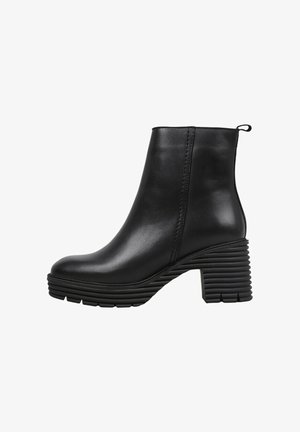 Bottine noire en cuir lisse, avec un talon carré à rainures horizontales, un bout rond et une languette à l'arrière.