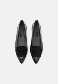 Balerini din piele patentă neagră, cu vârfuri ascuțite și un accent pătrat din suede negru contrastant pe vamp. Interior etichetat "Super Soft."