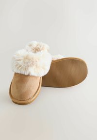 Brune ruskindsindslipper med en fluffy cremefarvet pelsmanchet, rund form og tekstureret gummisål med riller for bedre greb.