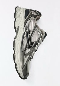Baskets de sport grises et noires avec panneaux en mesh, semelle épaisse et lacets blancs sur fond blanc uni.