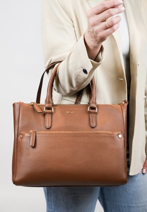Bruine leren tote bag met twee handvaten, ritssluiting en een voorvak. Voorzien van gouden hardware en een textuur oppervlak.