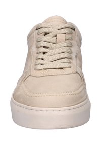 Beige suede sneakers with a rounded toe, flat white rubber sole, and woven laces. Features stitching detail along the side.
