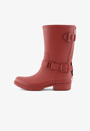 Rode rubberen regenlaars met gesp en verstelbare riem, ronde neus, platte zool, zijrits en een gladde textuur.