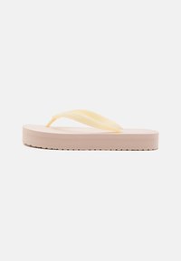 Yellow flip-flop with a textured pink sole. Features a smooth strap and embossed branding on the strap. Lightweight design.