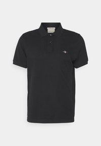 Camisa polo negra de material de algodón con un cuello clásico, tapeta de dos botones y un pequeño logotipo bordado en el pecho.