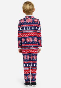 Röda och marinblå barnpyjamasar med ett mönster av snöflingor och jultre, tillverkade av ett mjukt tyg med lång ärm och byxor.