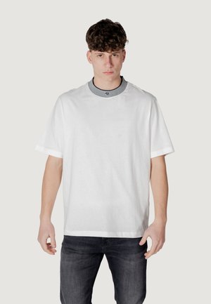 T-shirt bianco a maniche corte con collo rotondo, caratterizzato da un colletto a righe bianche e nere. Tessuto liscio, vestibilità rilassata, design minimal.