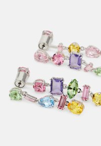 Pendientes de piedras preciosas coloridas con diversas formas: lágrima, óvalo y rectangular, montados en un hardware de plata con un diseño de cadena.