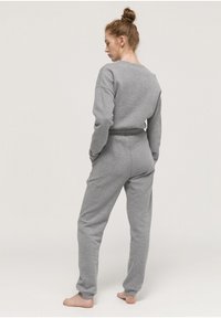 Grijze, lange mouwen sweatshirt en bijpassende jogger set. Zachte, textuurstof met een relaxte pasvorm. Heeft een gecinchet taille en taps toelopende mouwen.