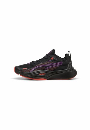 Baskets de sport noires avec des touches violettes et orange, empeigne en mesh, semelle épaisse marquée Nitro+ et une languette au talon.