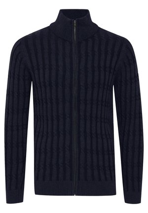 Marinblå zip-up cardigan med en texturerad ribbad design, hög krage och åtsittande muddar. Tillverkad av stickad tyg med ett konsekvent mönster.