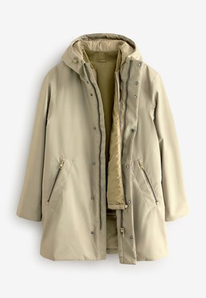 Veste imperméable beige avec capuche, dotée d'une fermeture éclair et à boutons-pression, de deux poches latérales zippées et d'une doublure intérieure chaude. Texture lisse.