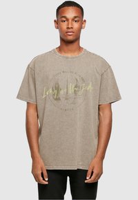 Camiseta gris de gran tamaño con cuello redondo, mangas cortas y un gráfico en la parte frontal que presenta el texto "Que vivan los Jedi" y un símbolo.