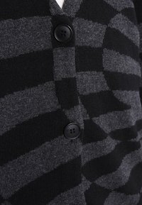 Cárdigan a rayas en negro y gris con escote en V, confeccionado en tejido de punto, que cuenta con dos botones negros y una textura suave.