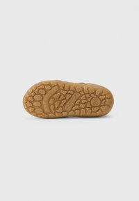 Kummi kinga tall pruunis värvitoonis tekstuuriga haardepinnaga. Omab reljeefset brändilogot ja ümarat kujundust, mis on loodud paindlikkust ja haarduvust silmas pidades.