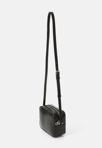 Bolso cruzado rectangular negro y brillante con cierre de cremallera, correa ajustable y diseño minimalista. Textura suave con costuras sutiles.