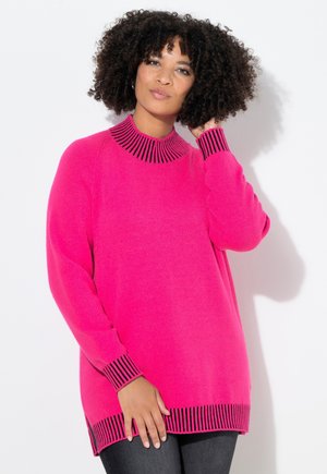 Pull en tricot fuchsia avec un col haut à rayures noires, des manches longues et des fentes sur les côtés de l'ourlet, offrant une texture douce.