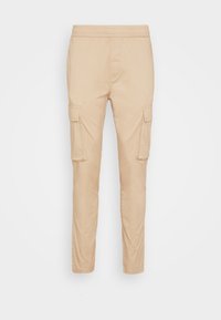 Pantalones cargo beige con una cintura elástica, dos bolsillos laterales y dos bolsillos en los muslos, fabricados con una tela suave y ligera.