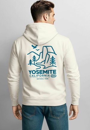 Cremefarbener Hoodie mit einem blauen Yosemite-Nationalpark-Graphic, das Berge, Bäume und einen Adler zeigt. Aus einem Baumwoll-Mischgewebe mit lockerer Passform.