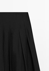 Black pleated skirt with stitched vertical seams, shown flat against a white background.