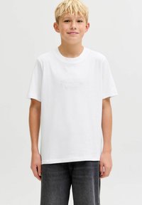 Camiseta de algodón blanca con escote redondo y mangas cortas. Presenta un sutil texto "Originals" en tono similar en el centro. Corte casual.