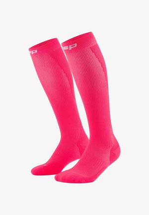 Knielange Socken in leuchtendem Pink, mit geripptem Textil, glattem Fußbett und verstärktem Zehenbereich. Die Markenkennzeichnung ist oben sichtbar.