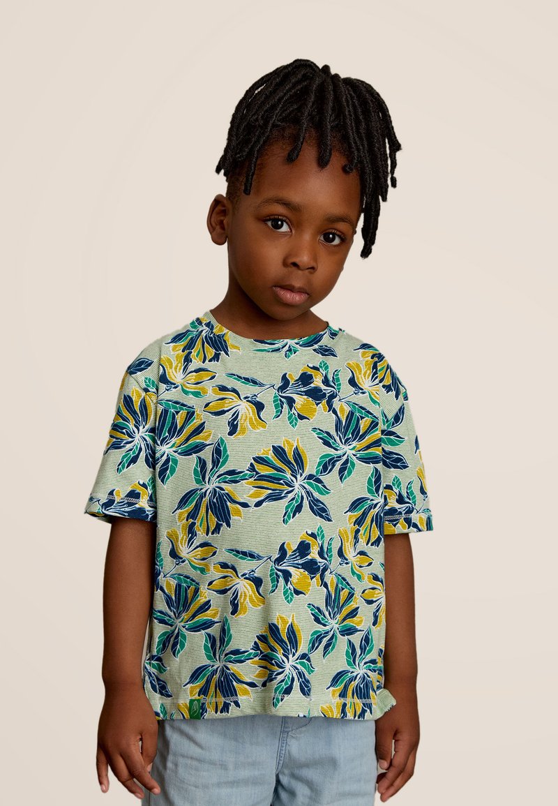 T-shirt à manches courtes de couleur vert clair avec un motif floral en jaune et bleu, présentant un col rond et une coupe décontractée.