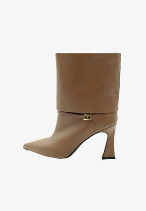 Stivale alla caviglia in pelle marrone con punta affusolata, gambale aderente e tacco sottile. Presenta un'accessorio a forma di fibbia dorata su una cinghia in pelle.