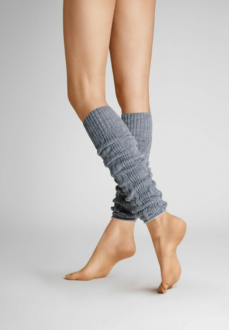 Grau gestrickte Beinstulpen mit geripptem Muster, enganliegendem und lässigem Design, das bis zur Mitte der Wade reicht, getragen mit baren Füßen.