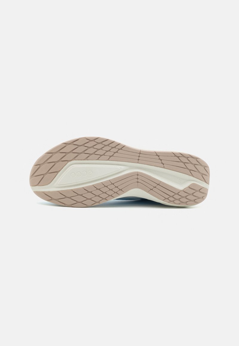 Die Laufsohle des Schuhs verfügt über ein strukturiertes Design mit einer Kombination aus hellbeigem Gummi und weißen Akzenten, die für Grip und Haltbarkeit sorgen.