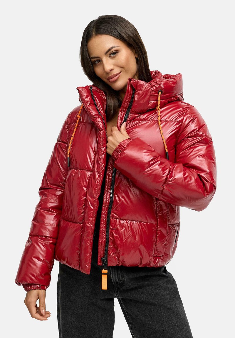 Chaqueta acolchada roja con un acabado brillante, cierre de cremallera, capucha con cordón y puños elásticos. Presenta detalles en naranja y un diseño cuadrado.