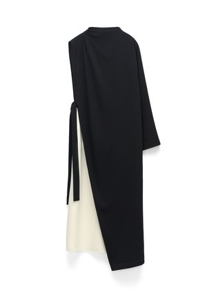 Asymetryczna czarno-biała sukienka midi z jednym długim rękawem i ozdobą zawiązaną z boku na białym tle.