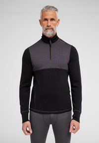 Sort og grå langærmet pullover med høj krave, lynlås ved halsen og kontrasterende farveblokdesign; har struktureret stof og sidelynlåse.
