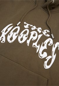 Brązowy hoodie z białym grafikiem tekstowym w zaokrąglonej czcionce, sznurkiem z metalowymi końcówkami oraz przednią kieszenią kangurką.