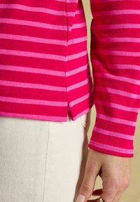 Kapeva pitkähiha, joka on varustettu vaakasuorilla raidoilla kirkkaan vaaleanpunaista ja vaaleanpunaista sävyä. Kangas on teksturoidun ribbikuvioinen ja sivusaumassa on halkiot.