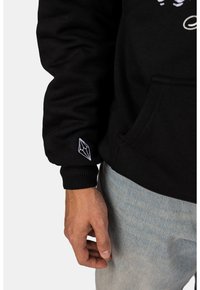 Černá mikina s kapucí a žebrovanými manžetami, s vyšitým geometrickým tvarem na rukávu. Neformální design, vyrobená z měkké tkaniny.