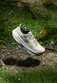 Light gray running shoe with a textured upper, flexible sole, and laces; features a minimalist design and subtle branding accents.