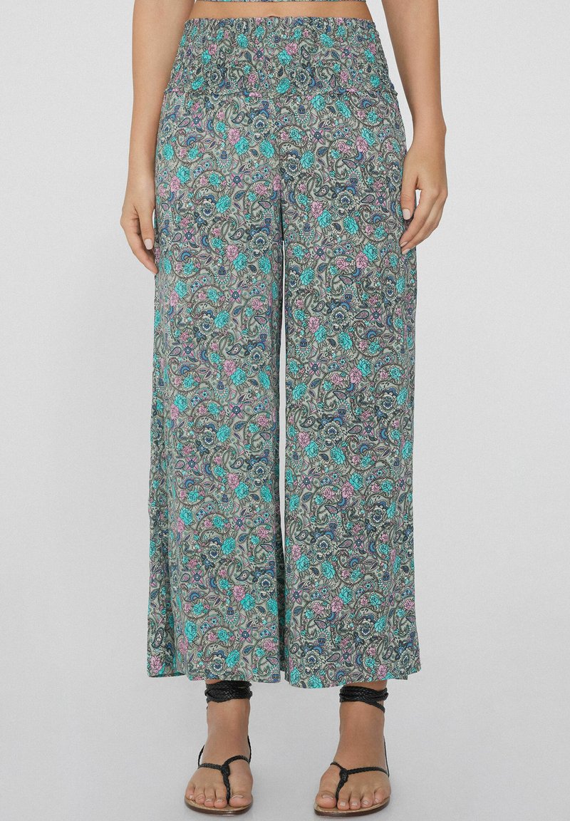 Spodnie o szerokich nogawkach z elastycznym paskiem w talii. Charakteryzują się kwiatowym wzorem paisley w odcieniach turkusu, różu i fioletu na ciemnym tle. Wykonane z lekkiego materiału.