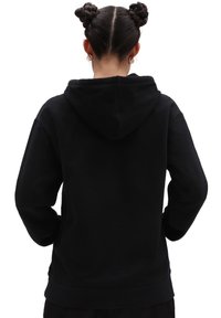 Sudadera con capucha negra hecha de una tela suave y de corte holgado. Cuenta con un bolsillo tipo canguro y puños y dobladillo de canalé. Se muestra la vista trasera.