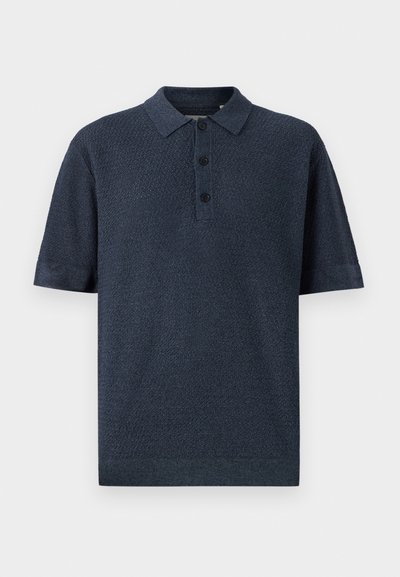 Polo de manga curta azul marinho, feito de tecido texturizado, com colarinho tradicional e tapeta de botão de três.