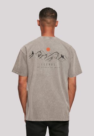 Lichtgrijze T-shirt met korte mouwen, voorzien van een zwarte berg- en boomafbeelding met een rode zon, en de tekst "ESCAPE" op de achterkant gedrukt.
