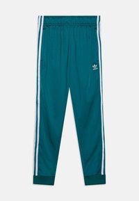 Pantalones deportivos color aguamarina con cintura elástica, rayas blancas en los lados y puños de tobillo estriados. Presentan un sutil logo de Adidas en la parte inferior de la pierna.